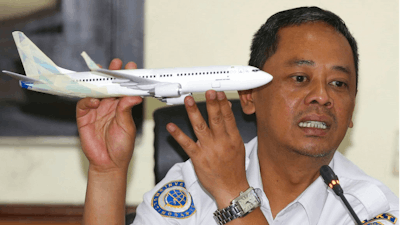 National Transportation Safety Committee investigator Nurcahyo Utomo holds a model of an airplane during a press conference on the committee's preliminary findings on their investigation on the crash of Lion Air flight 610, in Jakarta, Indonesia, Wednesday, Nov. 28, 2018. Black box data collected from their crashed Boeing 737 MAX 8 show Lion Air pilots struggled to maintain control as the aircraft's automatic safety system repeatedly pushed the plane's nose down, according to a preliminary investigation into last month's disaster.