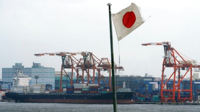 In this Aug. 24, 2018, photo, a Japanese flag is hoisted near the pier of a container terminal in Tokyo. Japan recorded a trade deficit in October but a recovery in exports after getting slammed by natural disasters in September, according to government data released Monday, Nov. 19, 2018. Exports grew 8.2 percent from the same month the previous year, the Finance Ministry said.