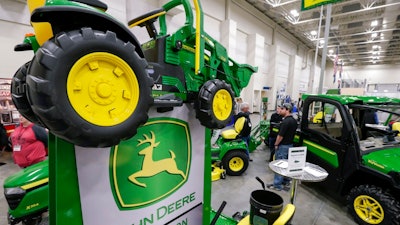 In this Feb. 23, 2018 file photo, John Deere products, including a toy tractor on the sign, are on display at the 'Spring into Spring' home and garden trade show in Council Bluffs, Iowa, John Deere, the maker of agricultural and construction equipment, reported a 46 percent boost in profit to $784.8 million, or $2.42 per share. But earnings, adjusted for pretax gains, came to $2.30 per share, 14 cents short of industry analyst projections, according to a survey by Zacks Investment Research.