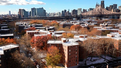 The Queensbridge Houses sit beneath the Ed Koch Queensboro Bridge, upper right, Friday, Nov. 16, 2018, in New York. Like most New York City housing projects, Queensbridge residents complain of poor conditions, lacking heat or hot water, or rats and roaches. The city has come under sharp criticism for the conditions of its public housing. Amazon is proposing to build a new headquarters nearby.