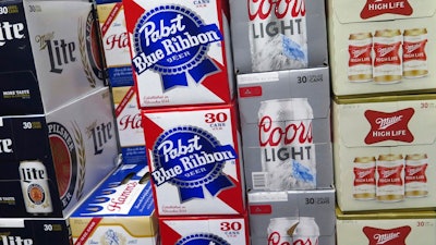 In this Nov. 8, 2018, file photo, cases of Pabst Blue Ribbon and Coors Light are stacked next to each other in a Milwaukee liquor store. MillerCoors and Pabst Brewing Co. settled a lawsuit Wednesday, Nov. 28, in which the hipster’s brand of choice claimed the bigger brewer lied about its ability to continue brewing Pabst's beers to put that company out of business.