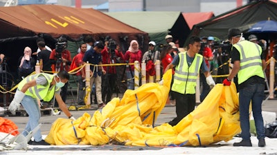 Investigators remove parts from Lion Air Flight 610 that crashed into Java Sea, for further investigation at Tanjung Priok Port in Jakarta, Indonesia, Friday, Nov. 2, 2018. New details about the crashed Lion Air's jet previous flight have cast more doubt on the Indonesian airline's claim to have fixed technical problems as hundreds of personnel searched the sea a fifth day Friday for victims and the plane's fuselage.