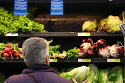 In this Nov. 20, 2018, file photo Lisa Dennis selects a head of green lettuce from the vegetable shelves at the East End Food Co-op Federal Credit Union in Pittsburgh. Health officials on Monday, Nov. 26, said it's OK to eat some romaine lettuce again. The Food and Drug Administration is narrowing last week’s alert warning people not to eat any romaine because of an E. coli outbreak. The agency hasn’t identified a source of contamination. But it says it's OK to eat romaine from parts of California and Arizona that were not harvesting when the illnesses began in October.