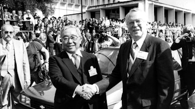 In this April 13, 1985 file photo, then Toyota Motor Corp. Chairman Eiji Toyoda, left, and then General Motors Corp. Chairman Roger B. Smith shake hands in front of a Chevrolet Nova as the new United Motor Manufacturing Inc., was inaugurated with a dedication ceremony at the Fremont, Calif., plant. The 50-50 joint-venture plant in Fremont, between Toyota Motor Corp. and U.S. automaker General Motors Co. started rolling out cars in 1984 and was heralded as a pioneer in international collaboration.