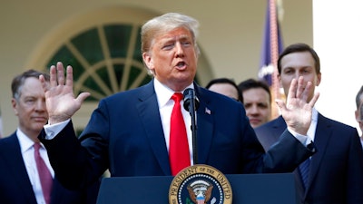 In this Monday, Oct. 1, 2018 file photo, President Donald Trump speaks as he announces a revamped North American free trade deal, in the Rose Garden of the White House in Washington. President Donald Trump insists his new North American trade deal will deliver a victory for U.S. factory workers by returning many high-paying jobs to the United States. Maybe. But a review of the agreement suggests that job gains for the U.S. would likely mean higher prices for consumers and more inefficiencies for businesses. The biggest winners might end up being robots and the companies that make them.