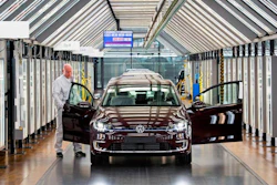 In this March 5, 2018 file photo, Roland Schulz makes the final check of an e-Golf electric car in the so-called light tunnel in the German car manufacturer Volkswagen's Transparent Factory in Dresden, Germany. Volkswagen said on Wednesday, Nov. 14, 2018, that it will convert three factories in Germany to manufacture electric cars, ramping up production of zero-local emission cars ahead of tougher European emissions standards.