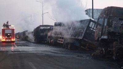 In this photo released by Xinhua News Agency, firefighters try to extinguish burning vehicles in the aftermath of an explosion at a plant operated by the Hebei Shenghua Chemical Industry Co. Ltd that destroyed dozens of vehicles nearby on Wednesday, Nov. 28, 2018 in Zhangjiakou city, northeastern China's Hebei province.