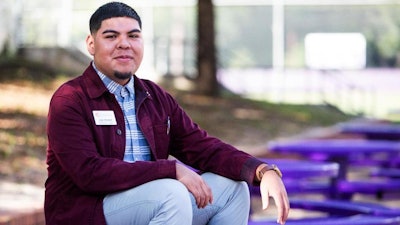 In this Oct. 18, 2018 photo, Jose Alvarez, 23, takes a break from speaking to high school students n Gainesville, Fla. Rural students are far less likely than urban and suburban peers to go to college, and the divide is growing deeper in places across Florida. Alvarez is a student advocate for Take Stock in Children, he spends the majority of his days talking to students about college options and graduation.