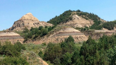 In this July 5, 2018, file photo, eroded hills are shown in Theodore Roosevelt National Park in western North Dakota. Attorneys for North Dakota's Health Department say the agency didn't improperly discount its own concerns about a proposed oil refinery near the park when it permitted the project earlier this year. The department and developer Meridian Energy Group want a state judge to reject a challenge by environmental groups to an air quality permit that allowed the company to begin construction last summer at the Davis Refinery site about 3 miles from the park.