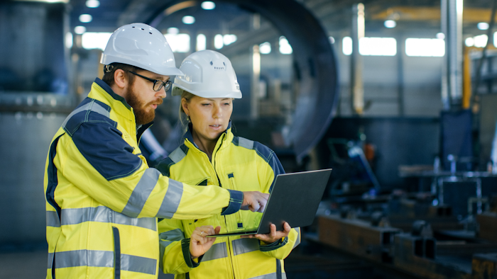 Male And Female Industrial Engineers In Hard Hats Discuss New Project While Using Laptop They Make Showing Gestures they Work In A Heavy Industry Manufacturing Factory 879813818 2313x1301 (1)
