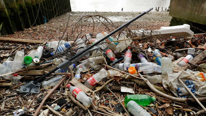 In this Feb. 5, 2018 file photo, plastic bottles and other plastics including a mop, lie washed up on the north bank of the River Thames in London. European Union officials agreed on Wednesday, Dec. 19, 2018, to ban some single-use plastics, such as disposable cutlery, plates and straws, in an effort to cut marine pollution. The measure will also affect plastic cotton buds, drink stirrers, balloon sticks, and single-use plastic and polystyrene food and beverage containers.