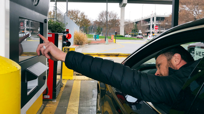 In this Friday, Dec. 7, 2018, photo, a rental car driver demonstrates a new biometric scanning machine by placing his finger on the reader at the Hertz facility at Hartsfield-Jackson Atlanta International Airport, in Atlanta. In a first for the rental car industry, Hertz is teaming up with Clear, the maker of biometric screening kiosks found at many airports and stadiums. Hertz says the partnership will slash the time it takes to pick up a rental car.