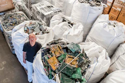 In this photo taken on July 13, 2018, founder of the company, Out Of Use, Mark Adriaenssens, stands among bags of electronic parts and components to be recycled at his warehouse in Beringen, Belgium. European Union nations are expected to produce more than 12 million tons of electronic waste per year by 2020, putting the Out Of Use company at the front of an expanding market, recuperating raw materials from electronic waste.