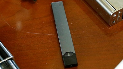 This April 10, 2018, file photo shows a Juul in Marshfield, Mass. Altria is spending $12.8 billion for a stake in e-vapor company JUUL as one of the world’s biggest tobacco companies tries to offset declining cigarette use.