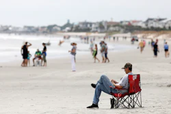 In this file photo, beach goers hang out at the Isle of Palms, S.C., as Hurricane Florence spins out in the Atlantic ocean. Environmental groups plan to sue the Trump administration over offshore drilling tests.