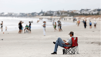 In this file photo, beach goers hang out at the Isle of Palms, S.C., as Hurricane Florence spins out in the Atlantic ocean. Environmental groups plan to sue the Trump administration over offshore drilling tests.