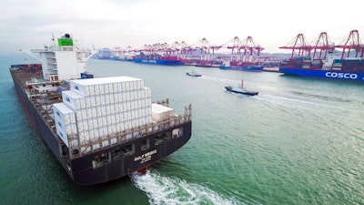 In this Dec. 8, 2018, photo, a container ship sails past a port in Qingdao in eastern China's Shandong province. News reports, Friday, Dec. 21, 2018, say Chinese leaders are promising tax cuts and more help to entrepreneurs in their 2019 economic plan amid official efforts to reverse a deepening slowdown in growth.