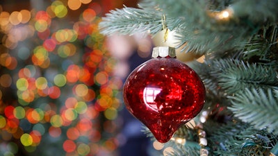 In this Friday, Nov. 30, 2018, photo, an ornament hangs on an artificial Christmas tree at the Balsam Hill Outlet store in Burlingame, Calif. About 80 percent of Americans who put up a Christmas tree now use a fake one and tree growers worry about those numbers growing as millennials begin to form traditions with their young children.