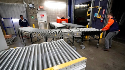 In this Nov. 9, 2018, file photo Laurence Marzo, left, and Ty Ford, right, move a conveyor belt into place to help unload a truck carrying merchandise at a Walmart Supercenter in Houston. On Friday, Dec. 7, the U.S. government issues the November jobs report.