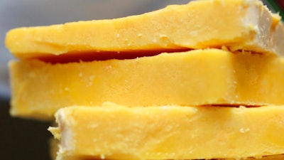 This May 28, 2015 file photo shows cheddar cheese Madison, Wis. The practice of adding color to cheddar cheese reaches back to when cheesemakers in England skimmed the butterfat from milk to make butter, according to Elizabeth Chubbuck of Murray’s Cheese in New York. The leftover milk was whiter, so pigments were added to recreate butterfat’s golden hue, she said.