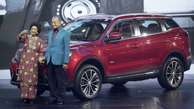 Malaysia Prime Minister Mahathir Mohamad, right, poses with his wife Siti Hasmah during the launch of Proton's new SUV.