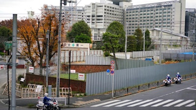 Police motorcycles pass by Tokyo Detention Center, background, where former Nissan chairman Carlos Ghosn is being detained, Monday, Dec. 10, 2018, in Tokyo. Tokyo prosecutors say Ghosn, who was arrested on Nov. 19, is suspected of underreporting income by 5 billion yen ($44 million) over five years. Japanese media are reporting that the government Securities and Exchange Surveillance Commission is accusing Nissan as a company, along with Ghosn and another executive, of underreporting income.
