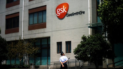 In this July 24, 2013, file photo a security guard walks in front of the GlaxoSmithKline building in Shanghai, China. Shares of Tesaro soared early Monday, Dec. 3, 2018, after GlaxoSmithKline said it would pay about $5.1 billion in cash to buy the cancer drugmaker.