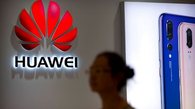 In this July 4, 2018, file photo, a shopper walks past a Huawei store at a shopping mall in Beijing. Canadian authorities said Wednesday, Dec. 5, 2018, that they have arrested the chief financial officer of China's Huawei Technologies for possible extradition to the United States.