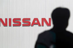In this Nov. 21, 2018, file photo, a man walks past the logo of Nissan Motor Co. at Nissan Motor Co. Global Headquarters in Yokohama near Tokyo. Nissan, the Japanese automaker under scrutiny after its former chairman Carlos Ghosn was arrested on suspicion of financial misconduct, is recalling 150,000 vehicles spanning 11 models in Japan for dubious inspections for brakes and steering.