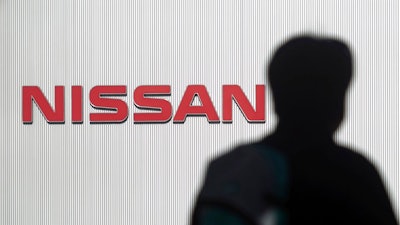 In this Nov. 21, 2018, file photo, a man walks past the logo of Nissan Motor Co. at Nissan Motor Co. Global Headquarters in Yokohama near Tokyo. Nissan is among a growing list of top-name Japanese companies whose corporate governance has been found lacking in recent years.