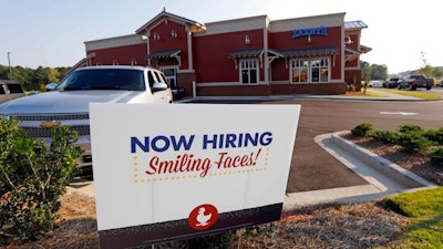 This July 25, 2018, file photo shows a help wanted sign at a new Zaxby's restaurant in Madison, Miss. On Monday, Dec. 10, the Labor Department reports on job openings and labor turnover for October.