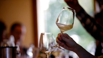 In this image taken on Monday, Oct. 15, 2018, an expert wine tester shakes a glass of Prosecco during a wine testing at the Case Paolin farm, in Volpago del Montello, Italy. Prosecco has become the best-selling sparkling wine in the world, and experts say it is eroding the more casual corner of champagne's market while aiming higher. Its production eclipsed champagne's five years ago and is now 75 percent higher at 544,000 bottles three-quarters of which for export.0 bottles three-quarters of which for export.