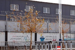 In this Wednesday, Dec. 5, 2018, photo, two layers of barbed wire fencing ring the 'Hotan City apparel employment training base' where Hetian Taida has a factory in Hotan in western China's Xinjiang region. This is one of a growing number of internment camps in the Xinjiang region, where by some estimates 1 million Muslims are detained, forced to give up their language and their religion and subject to political indoctrination. Now, the Chinese government is also forcing some detainees to work in manufacturing and food industries. Some of them are within the internment camps; others are privately owned, state-subsidized factories where detainees are sent once they are released.
