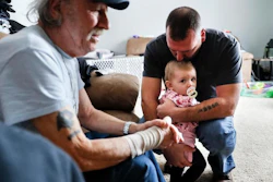 In this Nov. 28, 2018 photo, Tom Wolikow, right, holds his daughter Annabella alongside his father John, left, at their home in Warren, Ohio. It was working-class voters who bucked the area's history as a Democratic stronghold and backed Donald Trump in 2016, helping him win the White House with promises to put American workers first and bring back disappearing manufacturing and steel jobs. Whether they stick with him after this week's GM news and other signs that the economy could be cooling will determine Trump's political future.