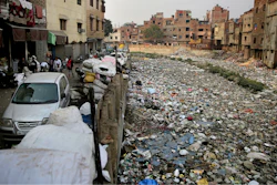 In this Saturday, Dec. 8, 2018 photo piles of electronic waste is placed next to a drain chocked with plastic and garbage in New Delhi, India.