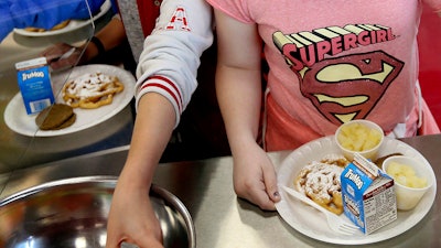 In this 2017 file photo, students line up for lunch at a middle school in Sandy, Utah. The U.S. Department of Agriculture recently announced the scaling back of contested school lunch standards implemented under the Obama administration.