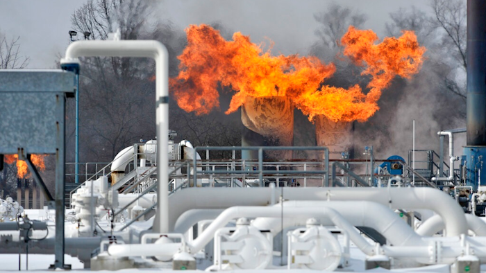 Fire comes out of the top of two silo-looking structures at the compressor station at Consumers Energy in Armada Township, Mich. Consumers Energy has called on customers to voluntarily reduce their natural gas usage following a fire at a suburban Detroit gas compressor station amid bitterly cold weather. The Jackson-based utility says no one was injured in the fire Wednesday, Jan. 30, 2019, at its Ray Natural Gas Compressor Station in Macomb County. The cause of the fire was under investigation.