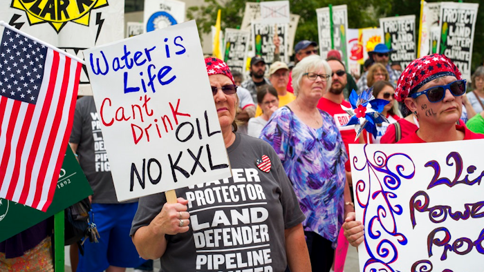 In this Aug. 6, 2017 file photo, demonstrators against the Keystone XL pipeline listen to speakers in Lincoln, Neb. Justice Department attorneys and the Canadian company behind the proposed Keystone XL oil pipeline say the U.S. government shutdown shouldn't delay a court hearing on a judge's decision to halt construction. Justice Department attorney Bridget McNeil said in a court filing Monday, Jan. 7, 20189, that federal attorneys' participation in the hearing next Monday in U.S. District Court in Great Falls isn't necessary.