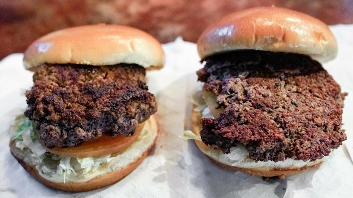 A conventional beef burger, left, is seen Friday, Jan. 11, 2019, next to 'The Impossible Burger', right, a plant-based burger containing wheat protein, coconut oil and potato protein among it's ingredients. The ingredients of the Impossible Burger are clearly printed on the menu at Stella's Bar & Grill in Bellevue, Neb., where the meat and non-meat burgers are served. More than four months after Missouri became the first U.S. state to regulate the term 'meat' on product labels, Nebraska's powerful farm groups are pushing for similar protection from veggie burgers, tofu dogs and other items that look and taste like meat.