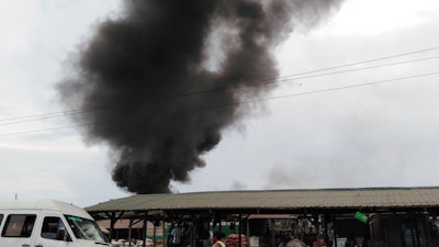 In this Nov. 26, 2018, photo, plumes of smoke rise above the Agbogbloshie dump site in Accra, Ghana. The billowing black smoke comes from the many informal e-waste recyclers who take unwanted electronics, strip them of their cables and burn away the protective covers to reach the valuable copper beneath.