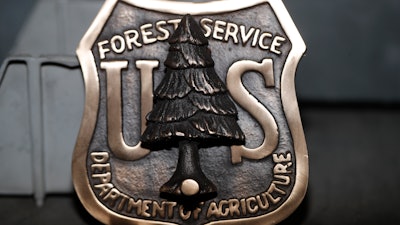A door knocker made for the U.S. Forest Service is shown at Western Heritage Co. Thursday, Jan. 24, 2019, in Loveland, Colo. Lynch saw online orders collapse almost immediately after the government shut down Dec. 22. The company sells buckles, keychains, commemorative coins and badges to employees of the Fish and Wildlife Service, the Forest Service, the Bureau of Land Management and other agencies. It also sells patches and some clothing.