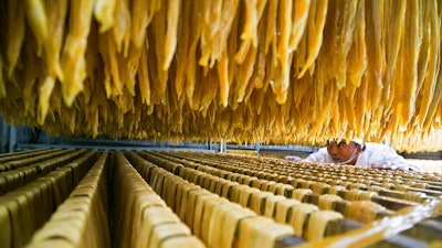 In this Jan. 10, 2019, photo released by Xinhua News Agency, a worker checks on a soybean food at a processing factory in Xiaotun Township of Dafang County in Bijie, southwest China's Guizhou Province. China's trade growth slowed in 2018 as a tariff battle with Washington heated up and global consumer demand weakened. Exports rose 7.1 percent, customs data showed Monday, Jan. 14, 2019 down from the 7.9 percent reported earlier for 2017. Import growth declined to 12.9 percent from the previous year's 15.9 percent.