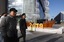 In this Friday, Jan. 4, 2019, photo, Chinese residents pass by a decor marking the new year outside a shopping mall in Beijing. A U.S. delegation led by deputy U.S. trade representative, Jeffrey D. Gerrish arrived in the Chinese capital ahead of trade talks with China. China sounded a positive note ahead of trade talks this week with Washington, but the two sides face potentially lengthy wrangling over technology and the future of their economic relationship.