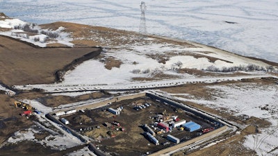 This Feb. 13, 2017, aerial file photo shows a site where the final phase of the Dakota Access Pipeline near the Missouri River took place with boring equipment routing the pipeline underground and across Lake Oahe to connect with the existing pipeline in Emmons County in Cannon Ball, N.D. The developer of the Dakota Access oil pipeline missed a year-end deadline to plant thousands of trees along the pipeline corridor in North Dakota, but the company said it was still complying with a settlement of allegations it violated state rules during construction.