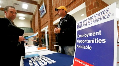 In this Nov. 2, 2017, file photo a recruiter from the postal service, right, speaks with an attendee of a job fair in the cafeteria of Deer Lakes High School in Cheswick, Pa. Even with fear of a global economic slump depressing stock markets, Friday, Jan. 4, 2019 jobs report for December is expected to offer reassurance that the U.S. economy remains sturdy and on track to expand for a 10th straight year.