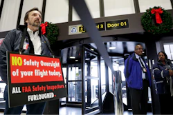 Federal Aviation Administration employee Michael Jessie, who is currently working without pay as an aviation safety inspector for New York international field office overseeing foreign air carriers, holds a sign while attending a news conference at Newark Liberty International Airport in Newark, N.J.