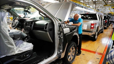 In this Sept. 27, 2018, file photo a United Auto Workers assemblyman works on a 2018 Ford F-150 truck being assembled at the Ford Rouge assembly plant in Dearborn, Mich. Ford Motor Co. reports financial results Wednesday, Jan. 23, 2019.