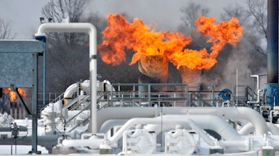 Fire comes out of the top of two silo-looking structures at the compressor station at Consumers Energy in Armada Township, Mich. Consumers Energy has called on customers to voluntarily reduce their natural gas usage following a fire at a suburban Detroit gas compressor station amid bitterly cold weather. The Jackson-based utility says no one was injured in the fire Wednesday, Jan. 30, 2019, at its Ray Natural Gas Compressor Station in Macomb County. The cause of the fire was under investigation.