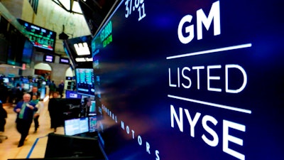 In this April 23, 2018, file photo, the logo for General Motors appears above a trading post on the floor of the New York Stock Exchange. The Canadian auto workers union is calling on people in Canada and the U.S. to stop buying General Motors vehicles made in Mexico. The Unifor union wants people to boycott vehicles with identification numbers that start with three. Unifor says it will publicize the boycott with television, newspaper and billboard ads. So far the United Auto Workers union in the U.S. is not joining the effort.
