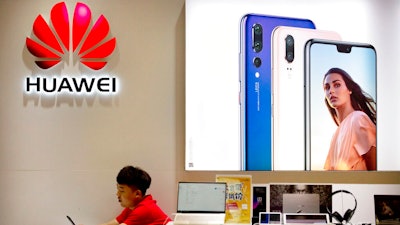 In this July 4, 2018, file photo, a sales clerk looks at his smartphone in a Huawei store at a shopping mall in Beijing. China has called on the United States to ‘stop the unreasonable crackdown’ on Huawei following the tech giant’s indictment on charges of stealing technology, violating trade sanctions and lying to banks.